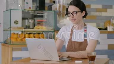 女人在电脑上打字，在咖啡馆接电话